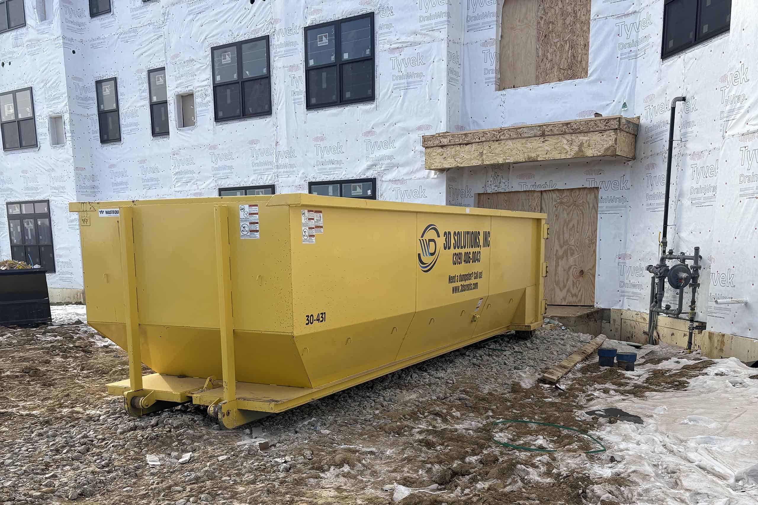 Construction site waste container for debris removal at building project.
