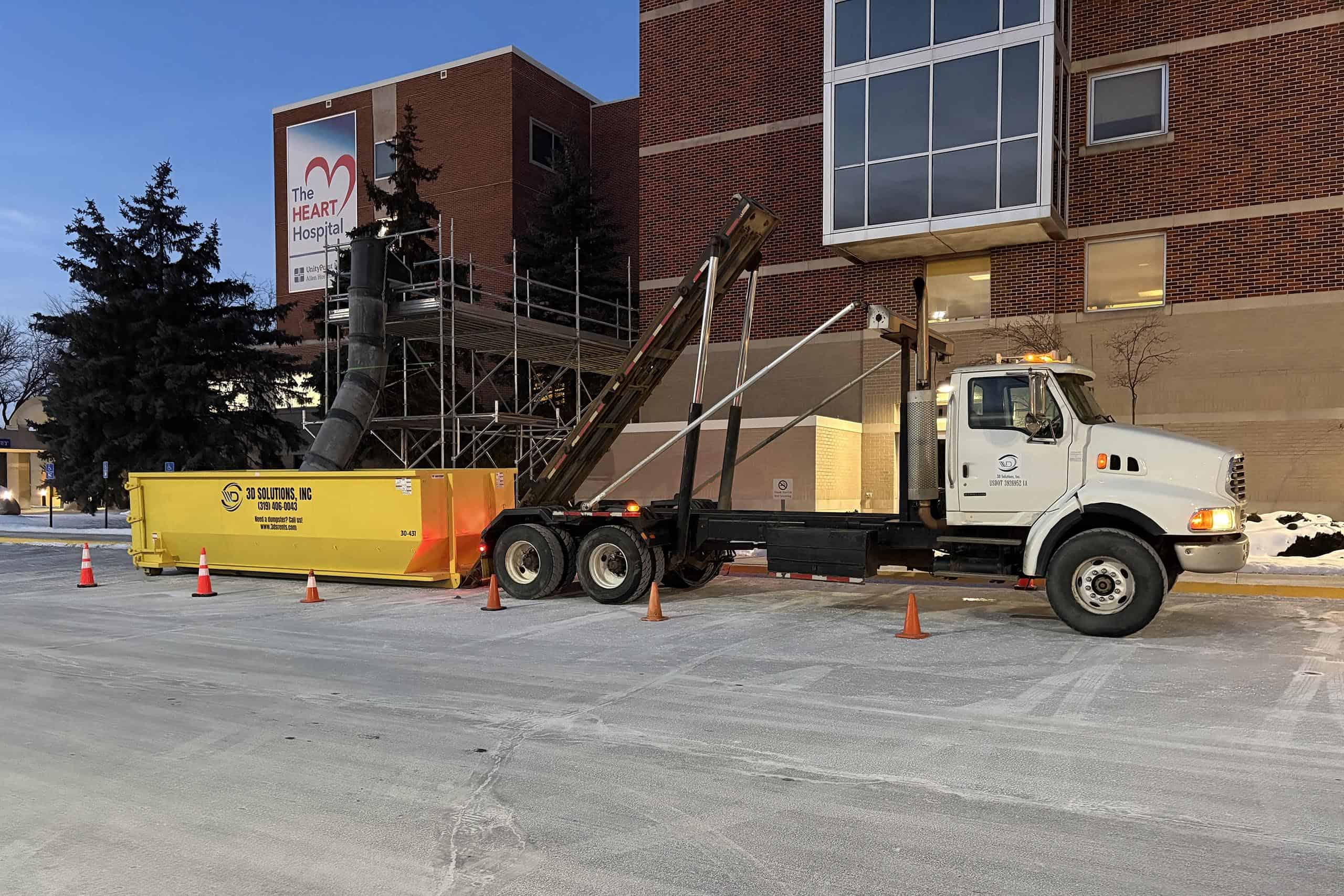 Mobile medical equipment transport truck outside hospital building.
