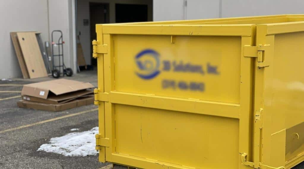 Yellow dumpster in a warehouse for office cleanout debris.