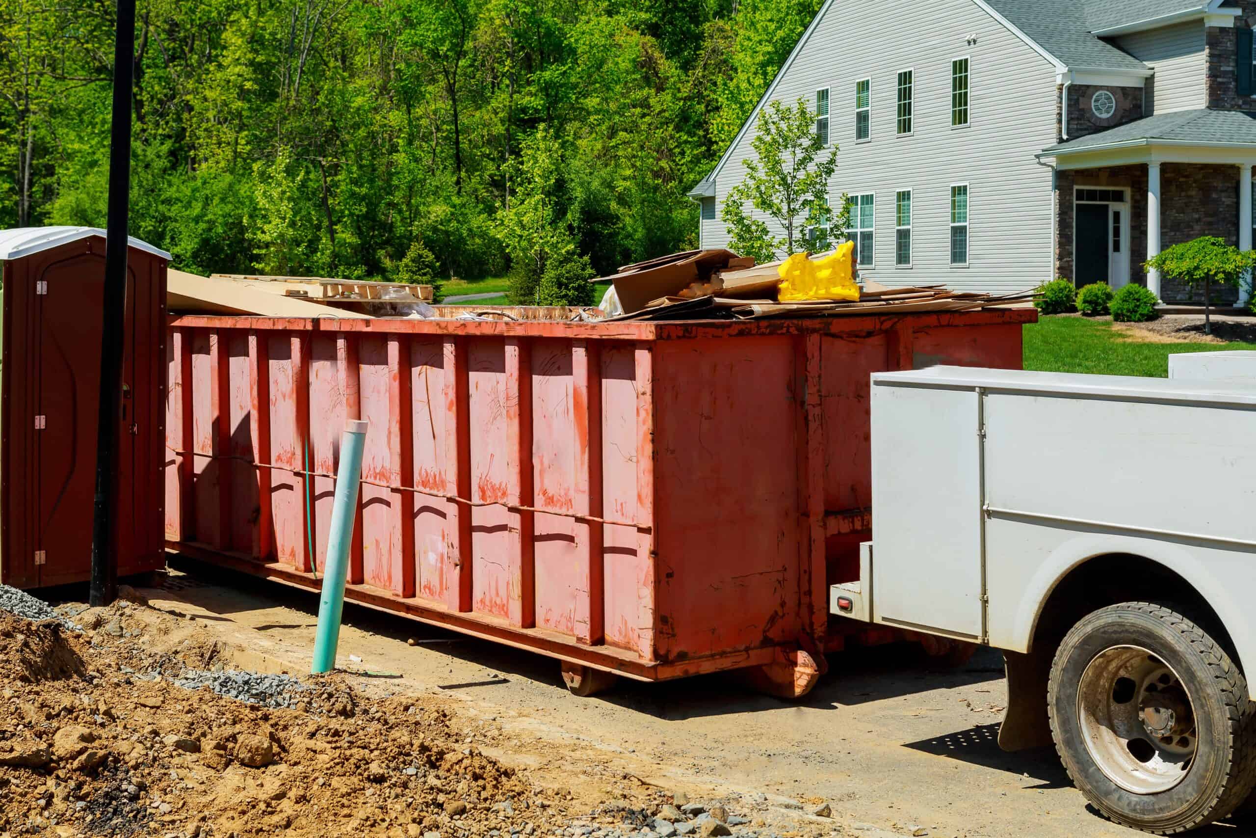 Dumpster Rental in Evansdale, IA 1 Homeowner loading household items into a roll-off dumpster