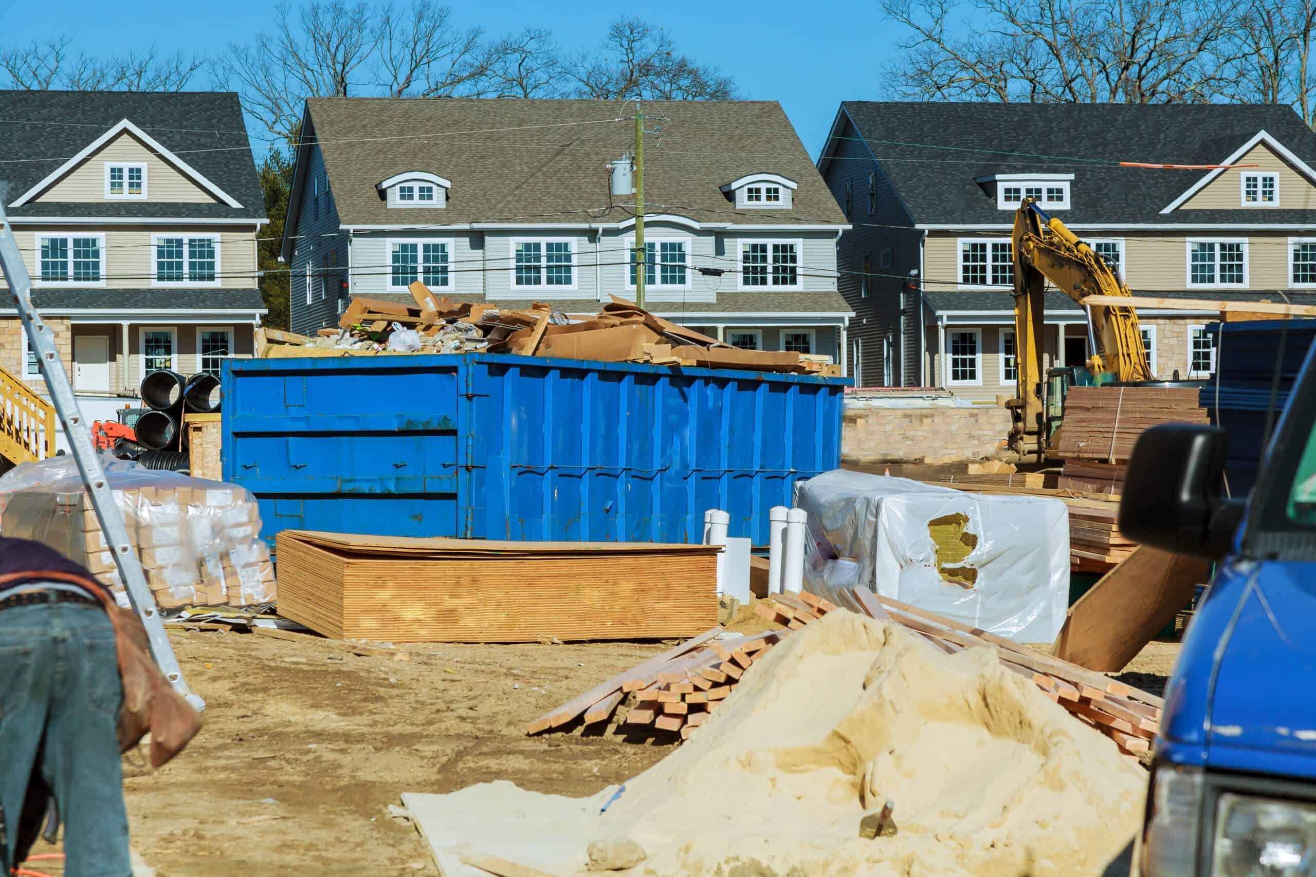Contractor loading construction debris into a roll-off dumpster