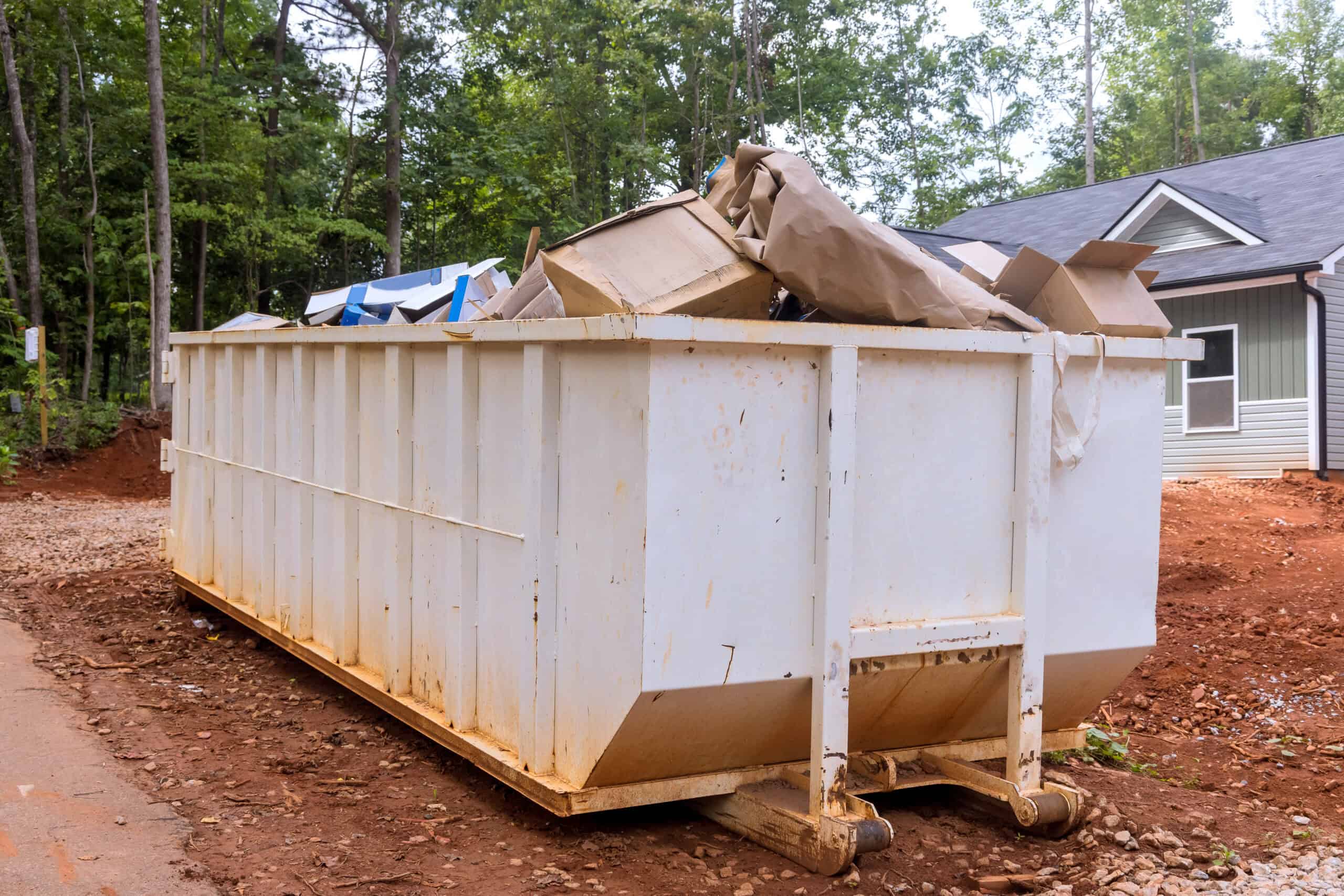 Dumpster Rental vs. City Bulk Trash Pickup 1 Large construction dumpster filled with debris at a residential site.