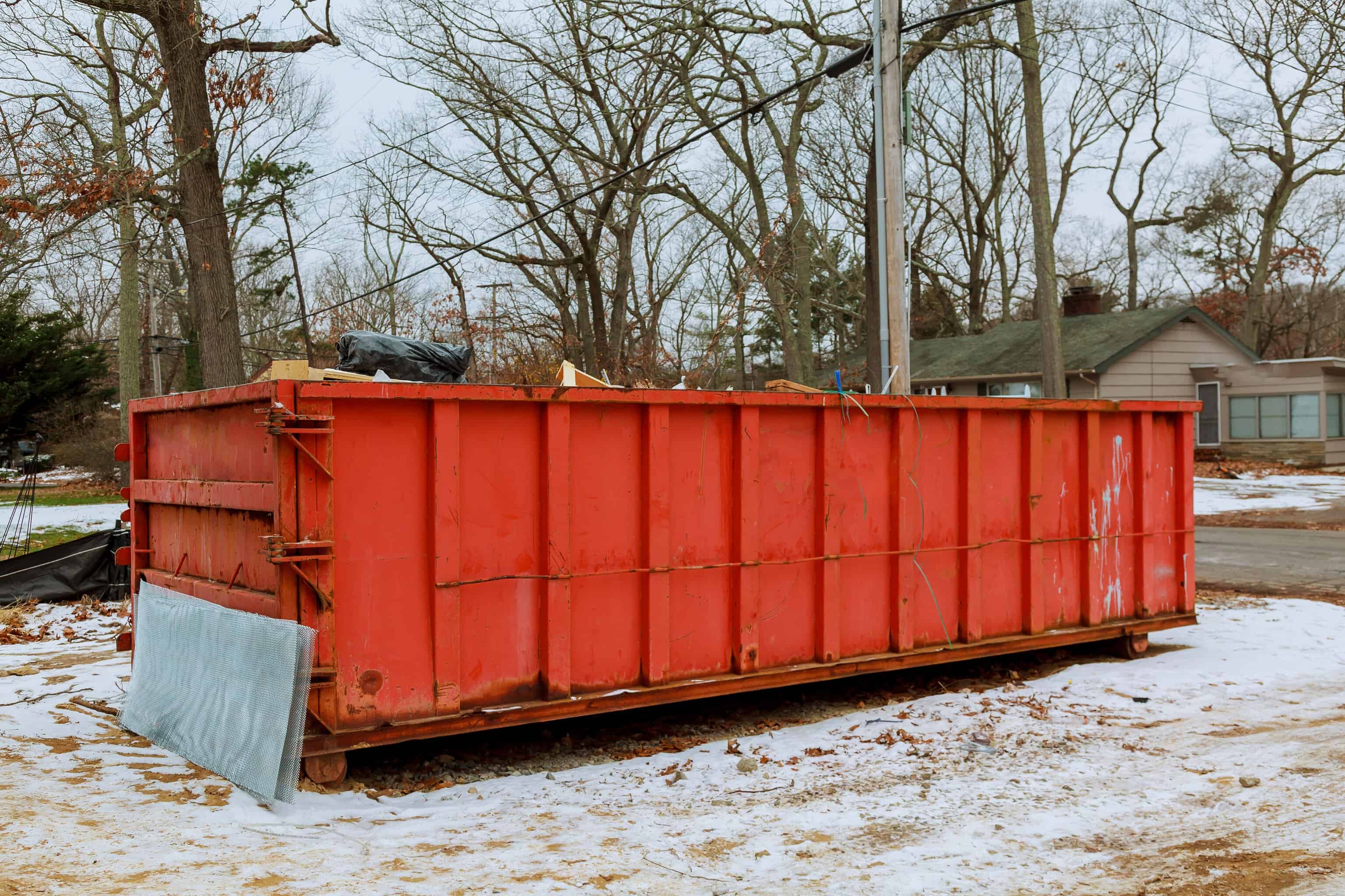 What Is a Roll-Off Dumpster and How Delivery Works 1 Open-top roll-off dumpster set on protective boards on a driveway.